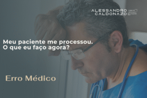 Médico de jaleco azul, preocupado se escorando em uma janela com o lhar reflexivo de preocupação por ter sido, hipoteticamente, processado por um paciente devido a um erro médico.